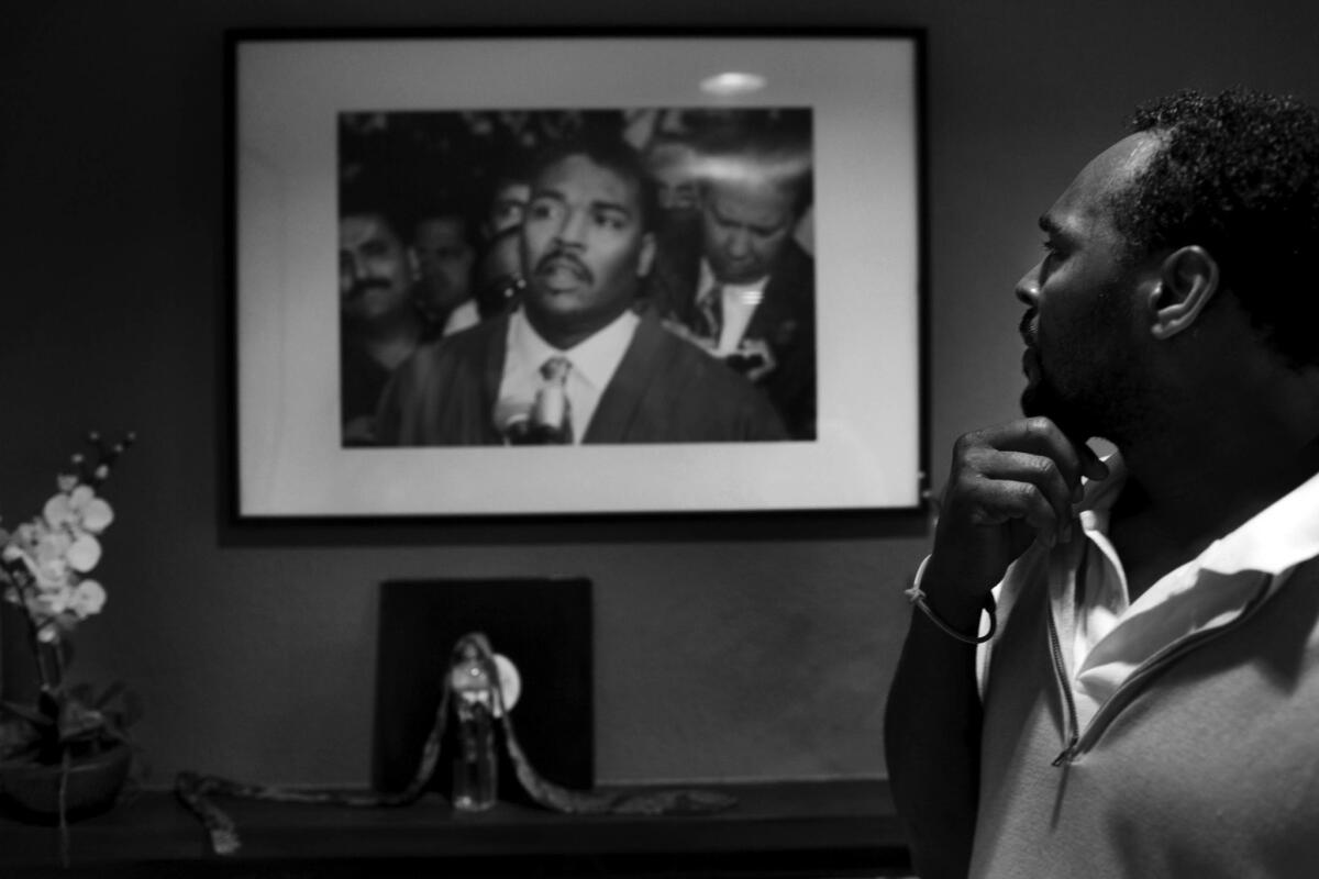 March 26, 2012: Rodney Glen King looks at a picture of himself from May 1, 1992, the third day of the Los Angeles riots, which hangs in the living room of his home in Rialto.. At that May 1, 1992, press conference, King uttered the famous words, "Can we all get along."