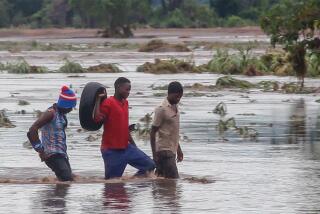 Personas caminan por una calle inundada, el martes 25 de enero de 2022, en Chikwawa, Malawi. (AP Foto, Archivo)