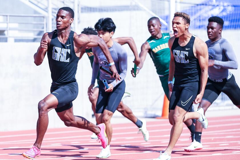 Jordan Coleman roars with approval after handing baton to Dijon Stanley as Granada Hills