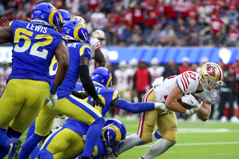 49ers running back Christian McCaffrey, #23, breaks away from the Rams defense in the fourth quarter.