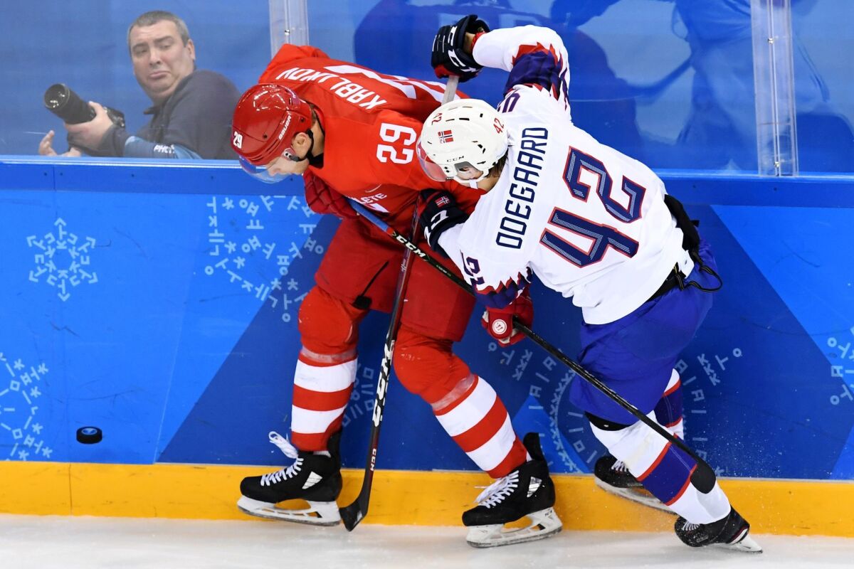 Russia's Ilya Kablukov, left, checks Norway's Henrik Odegaard in a men's quarterfinal hockey game.