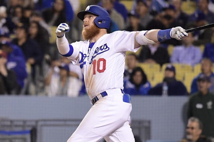 Los Angeles Dodgers' Justin Turner watches his three-run home run in front of Atlanta Braves catcher Tyler Flowers during the eighth inning of a baseball game Tuesday, May 7, 2019, in Los Angeles. This was Turner's third home run of the game. (AP Photo/Mark J. Terrill)
