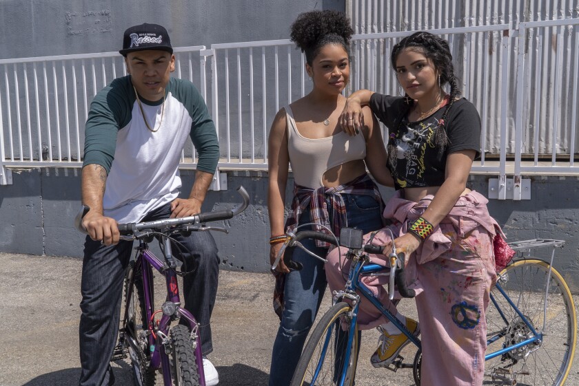 A man on a bicycle, next to a woman leaning on a woman on a bicycle