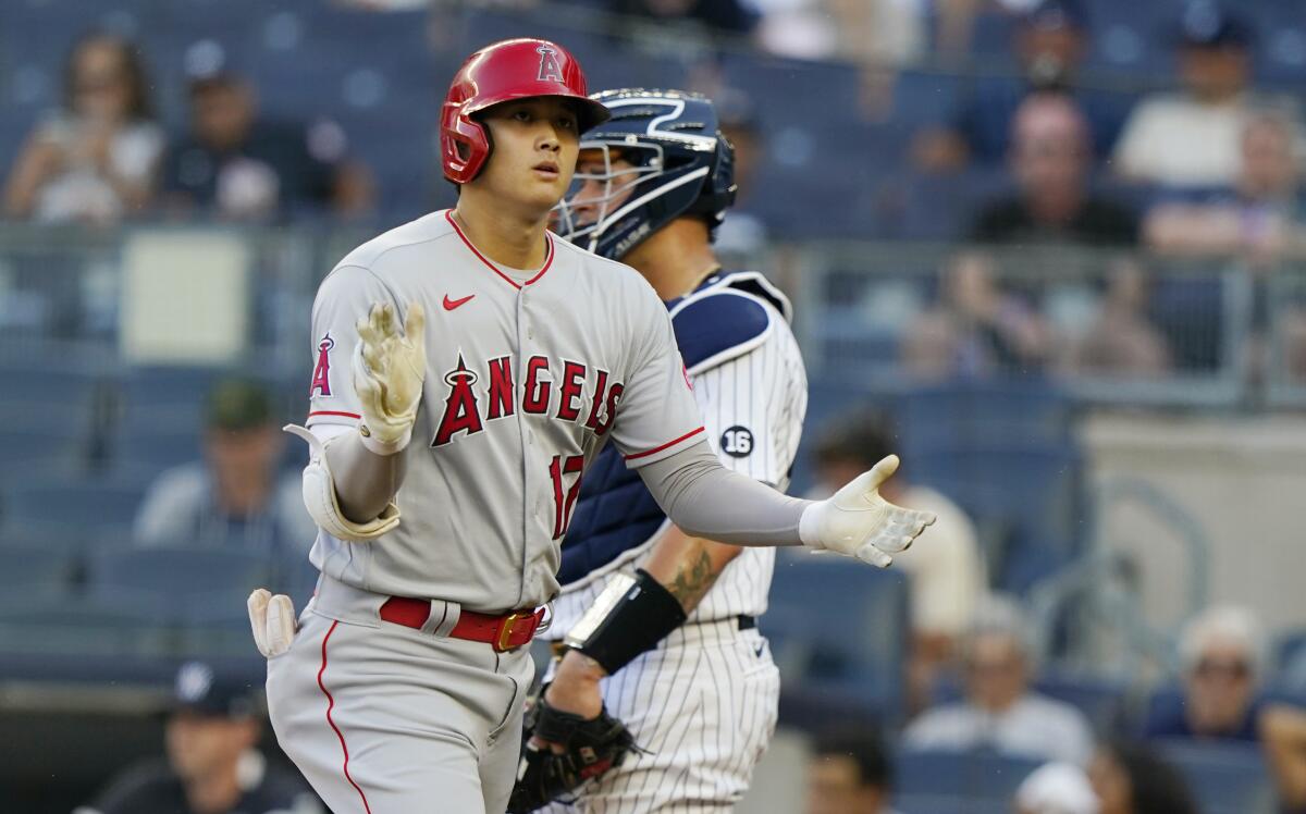 Shohei Ohtani claps as he crosses the plate after hitting a solo home run.