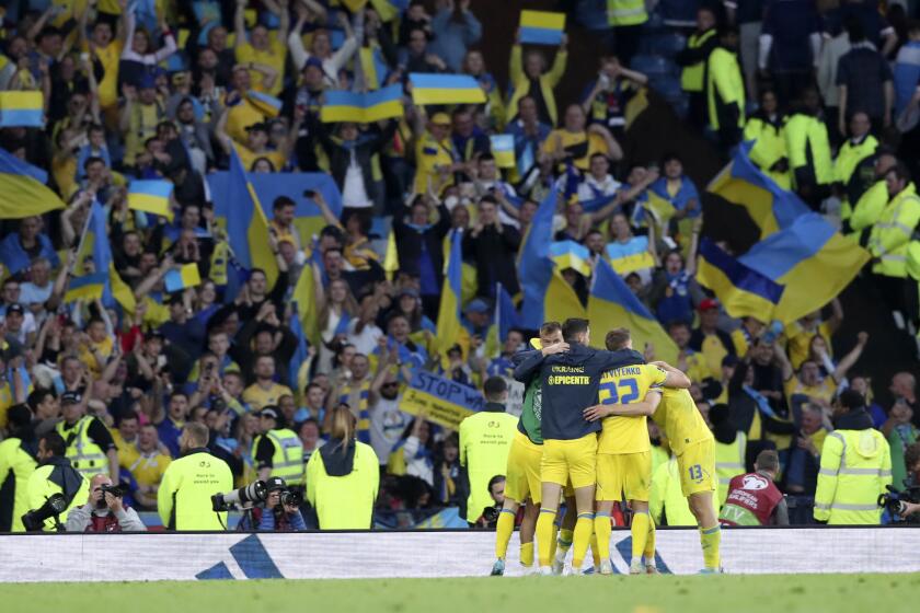 Ukrainian players celebrate at the end of the World Cup 2022 qualifying play-off soccer match between Scotland and Ukraine at Hampden Park stadium in Glasgow, Scotland, Wednesday, June 1, 2022. (AP Photo/Scott Heppell)
