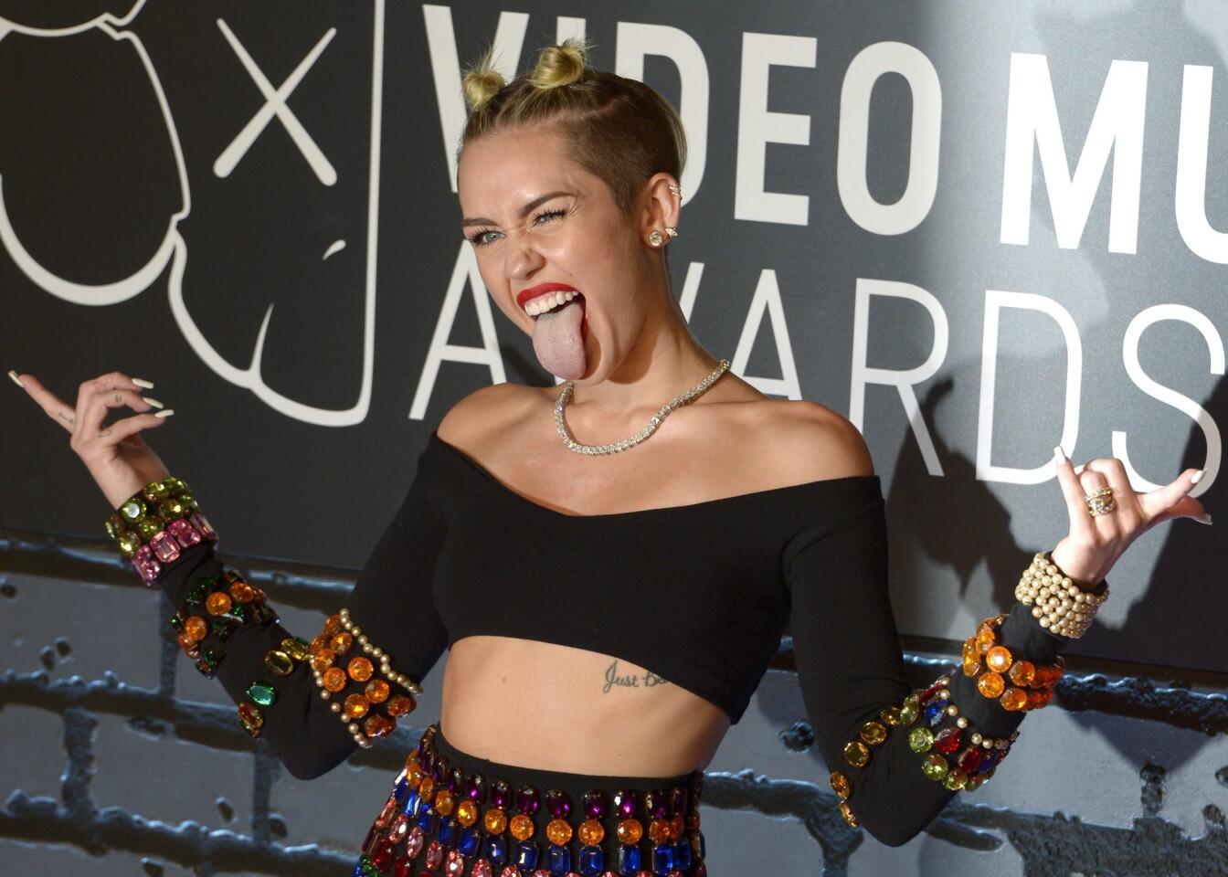 Miley Cyrus, who is hosting the MTV Video Music Awards this Sunday, is famous for her skimpy red carpet looks, such as this revealing midriff from the 2013 VMAs.