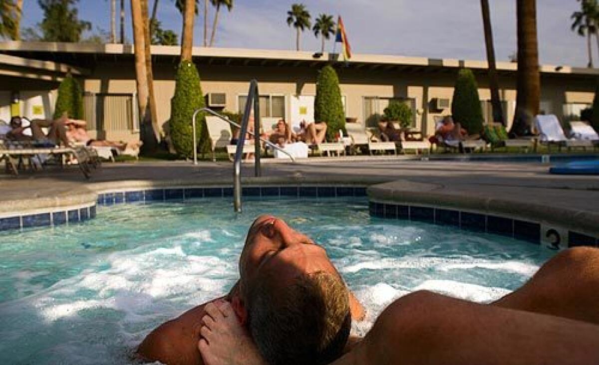 Jason Mitchell, 33, of Providence, RI, leans in to the touch of his boyfriend Adolfo Sanchez, 46, Boston, Mass., at INNdulge, a resort hotel for gay men in the heart of Warm Sands. Some say Palm Springs has become the gayest city in America.