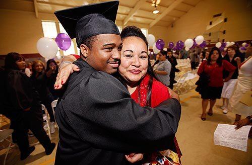 Alfred Stern hugs art teacher Julie Hernandez after graduating from Optimist High School in the Highland Park area of Los Angeles. Optimist High works with at-risk students.