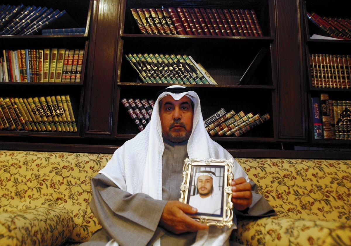 Khalid Odah holds a picture of his son Fawzi, one of two Kuwaiti detainees still being held at Guantanamo. Fawzi Odah contends in a lawsuit that he should be freed when the U.S. withdraws from Afghanistan, citing international law governing the treatment of prisoners of war.