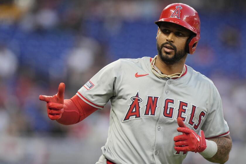 Los Angeles Angels' Aaron Hicks (12) gestures to his teammates after hitting a home run during the fourth inning of a baseball game against the Miami Marlins, Tuesday, April 2, 2024, in Miami. (AP Photo/Marta Lavandier)