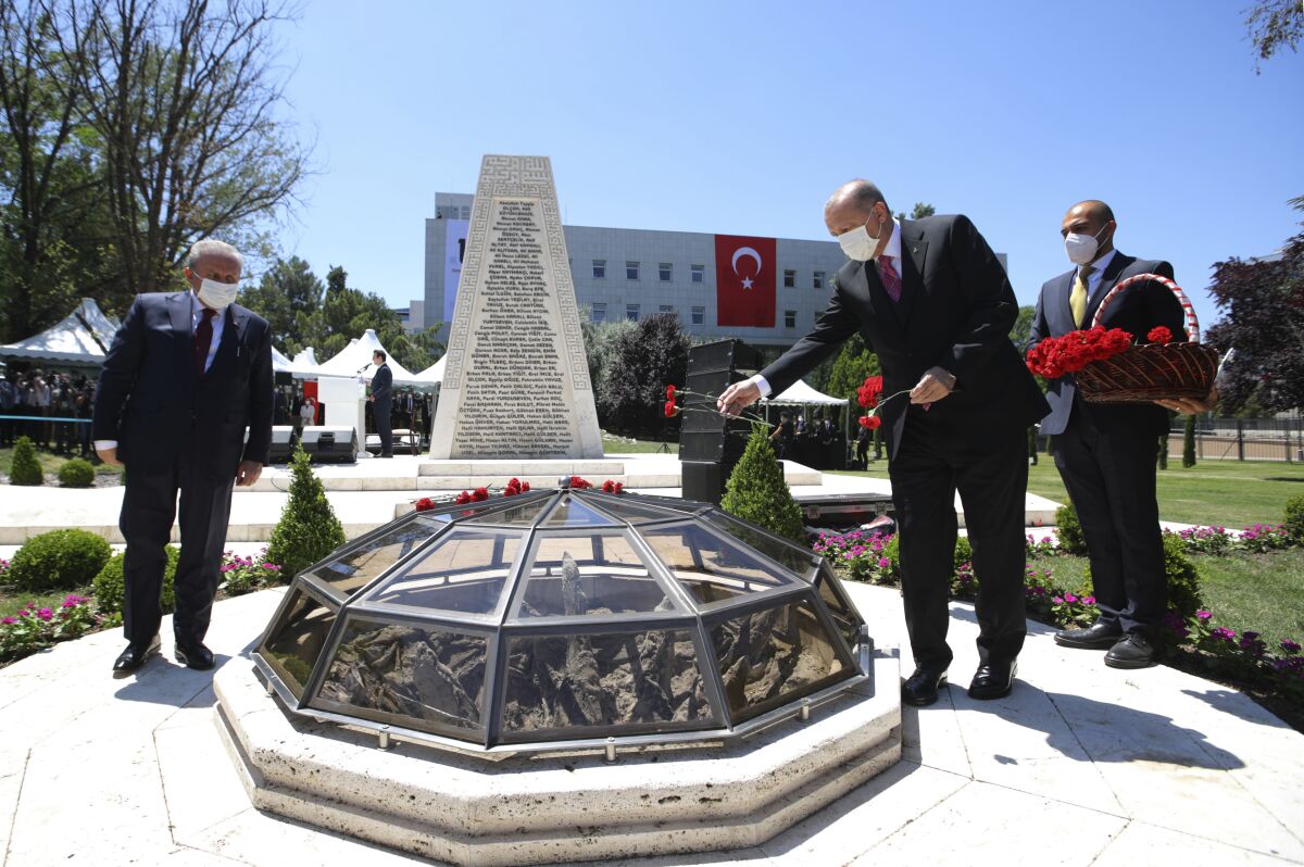 Turkey's President Recep Tayyip Erdogan places carnations at a monument during a ceremony in the capital Ankara, Turkey, Thursday, July 15, 2021. Turkey on Thursday marked the fifth anniversary of a failed coup attempt against the government, with a series of events commemorating victims who died trying to quash the uprising. (AP Photo)