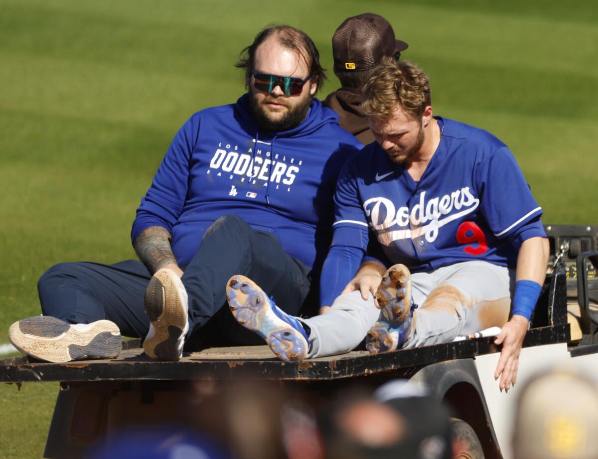 Dodgers infielder Gavin Lux is carted off after sustaining a knee injury Monday against the San Diego Padres.