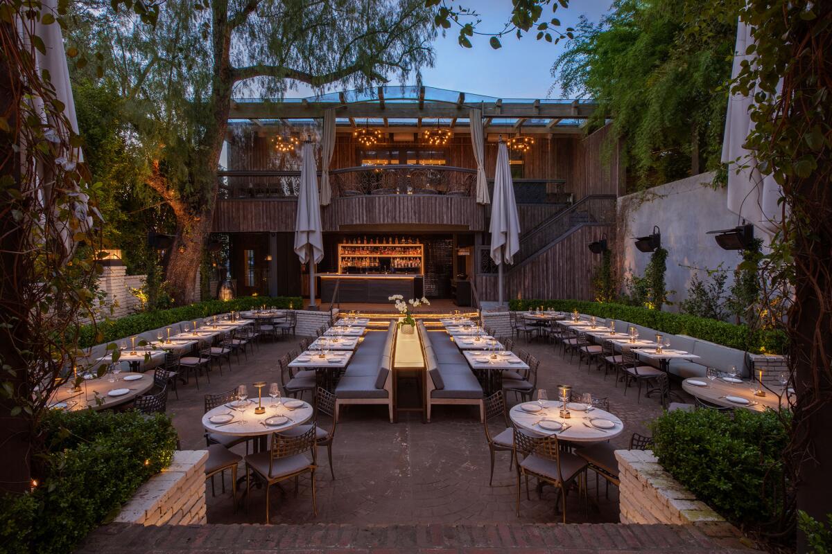 The exterior eating area at a new restaurant, at dusk.