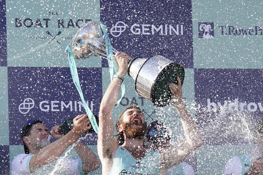 The Cambridge men's team celebrates with the trophy following the 169th Men's Gemini Boat Race 2024 on the River Thames, London, Saturday March 30, 2024. (Jonathan Brady/PA via AP)