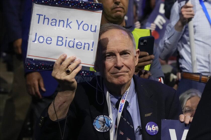 Un delegado sostiene un cartel mientras el presidente Joe Biden habla durante el primer día de la Convención Nacional Demócrata, el lunes 19 de agosto de 2024, en Chicago. (AP Foto/Jacquelyn Martin)