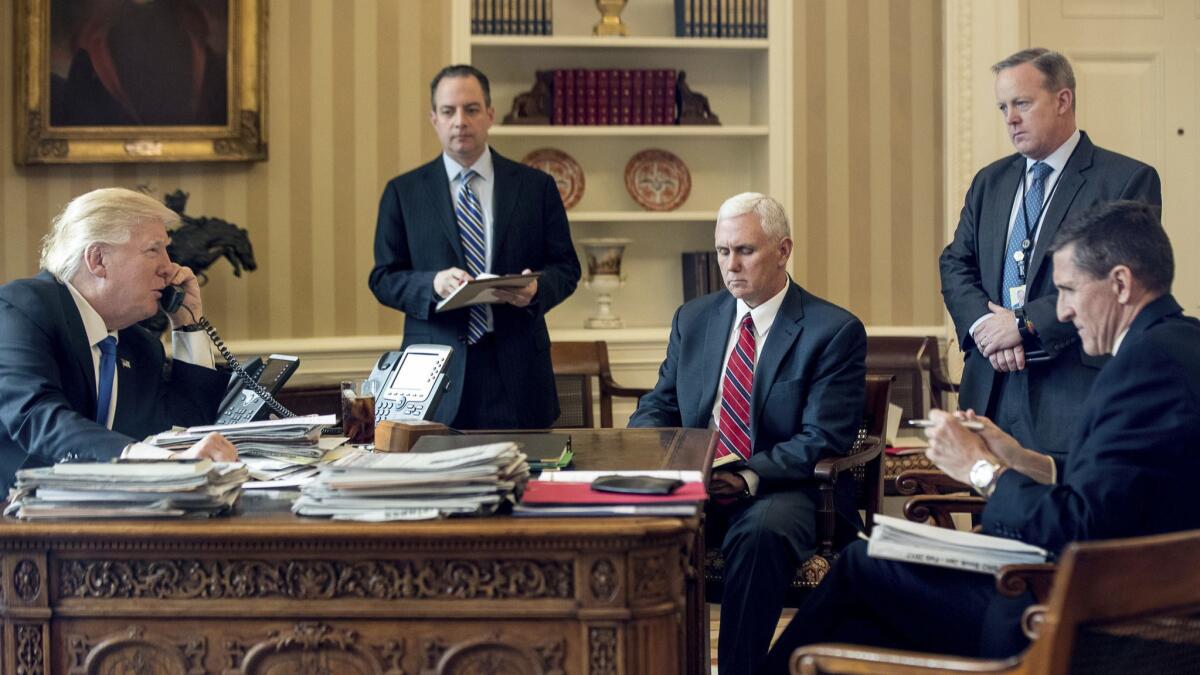 President Trump on Jan. 28 2017, with, from left, then-Chief of Staff Reince Priebus, Vice President Mike Pence, then-White House press secretary Sean Spicer and then-National Security Adviser Michael Flynn. Trump is on the phone with Russian President Vladimir Putin.