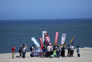 People protest at a beach toward the Fukushima Daiichi nuclear power plant, damaged by a massive March 11, 2011, earthquake and tsunami, in Namie town, northeastern Japan, Thursday, Aug. 24, 2023. The operator of the tsunami-wrecked Fukushima Daiichi nuclear power plant says it began releasing its first batch of treated radioactive water into the Pacific Ocean on Thursday — a controversial step, but a milestone for Japan's battle with the growing radioactive water stockpile. (AP Photo/Eugene Hoshiko)