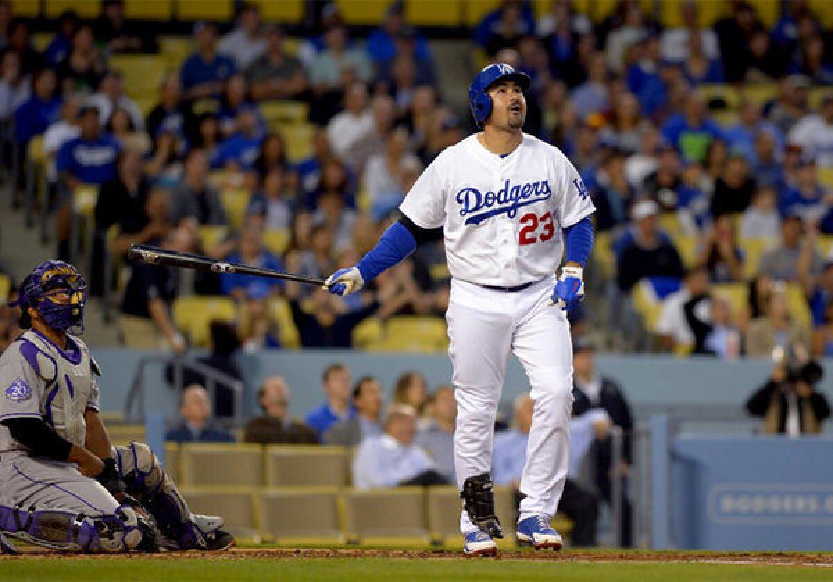 The Dodgers' Adrian Gonzalez, right, watches his two-run home run leave the park against the Colorado Rockies.