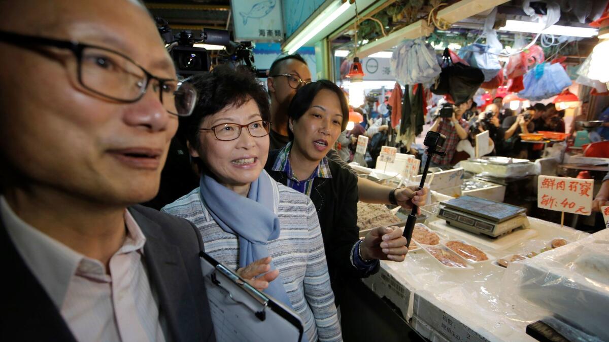 Former Chief Secretary Carrie Lam, second from left, visits a local market during an election campaign stop on March 23, 2017. (Kin Cheung / AP)