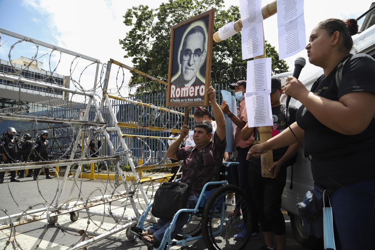 Un manifestante en silla de ruedas levanta una imagen del asesinado Monseñor 
