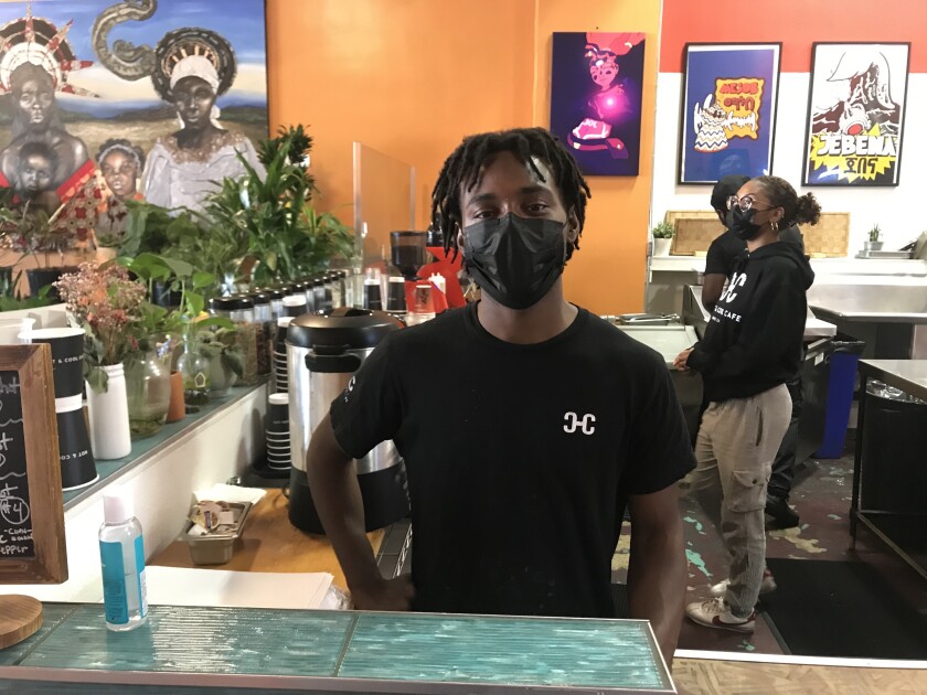 Seven Martin stands at the counter of the Hot + Cool Café in Leimert Park Village.