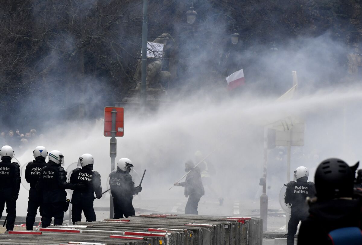 Police set off a water cannon against protesters during a demonstration in Brussels.