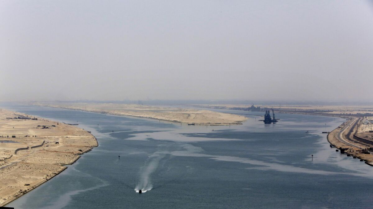 FILE - An army zodiac secures the entrance of a new section of the Suez Canal in Ismailia, Egypt, Aug. 6, 2015. Cash-strapped Egypt increased transit fees Tuesday, March 1, 2022, for ships passing through the Suez Canal, one of the world’s most crucial waterways, with hikes of up to 10%, officials said. (AP Photo/Amr Nabil, File)