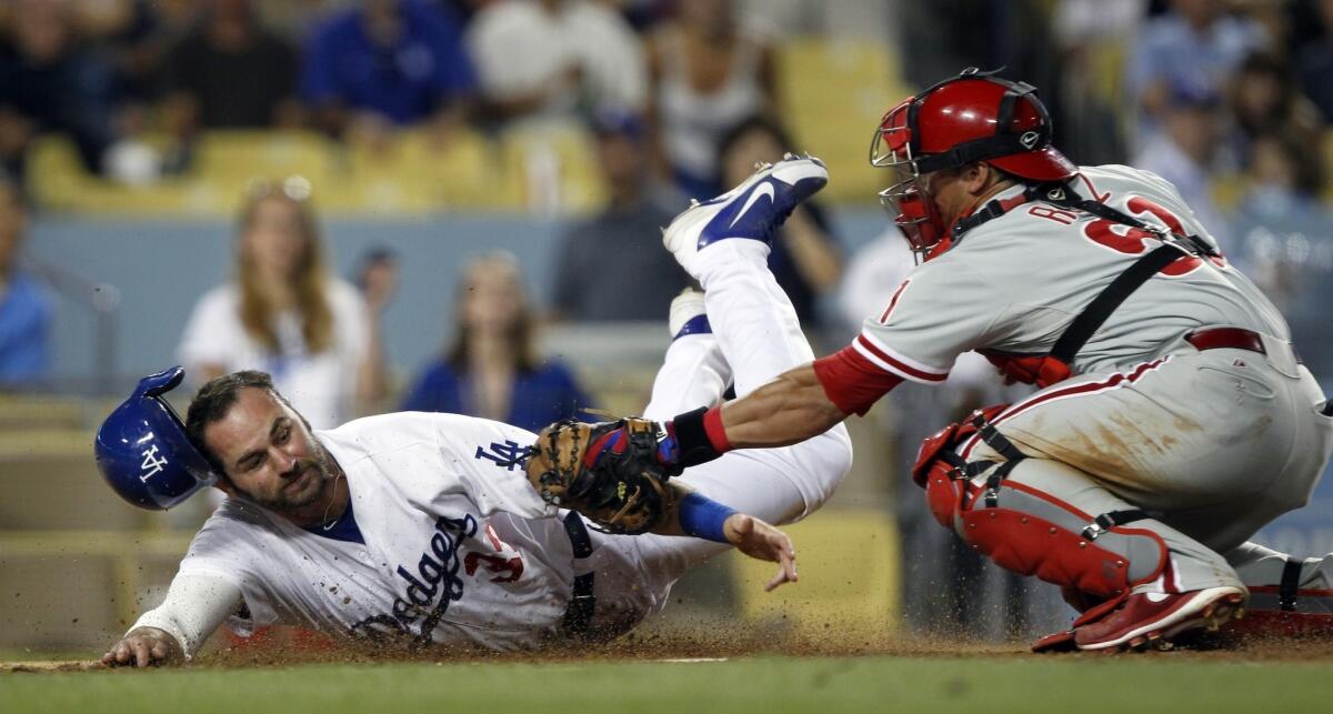 Dodgers outfielder Scott Van Slyke, left, is tagged out by Philadelphia Phillies catcher Carlos Ruiz during a game in June.