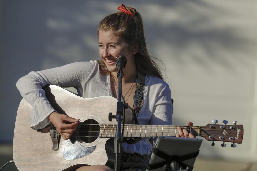 UPLAND, CA - APRIL 16: Alexa Capelli, a 20-year-old singer, who lives in the culdesac, sings at her neighborhood weekly gathering. Neighbors living in a culdesac of Upland got together and hold Neighborhood Safe Social Distancing gathering on weekly basis to keep the mood upbeat in the midst coronavirus pandemic. Alexa Capelli, a 20-year-old singer, who lives in the culdesac at 1400 block of Highpoint Street, entertains the neighbors with beautiful songs. Neighbors, who come from different professional background, like occupational therapist, law enforcement, school teacher, medical office administrator, x-ray technician and owner of thrift store, bring out their lawn chair and tables, sipping on their favorite drinks enjoy the weekly musical evening. Upland, CA. (Irfan Khan / Los Angeles Times)
