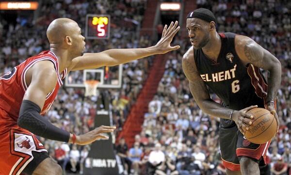 Chicago Bulls' Taj Gibson, left, guards the Miami Heat's LeBron James during first quarter action.