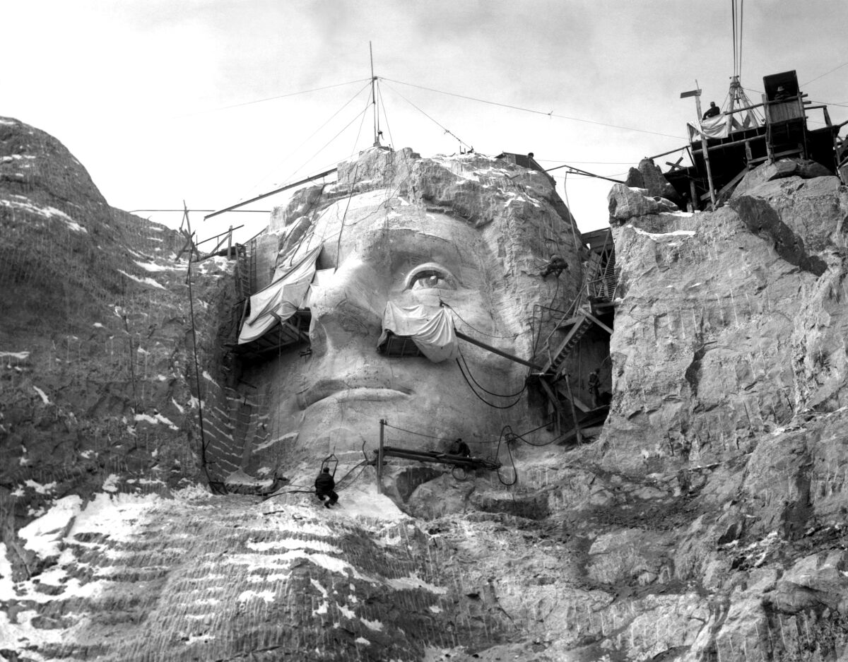 Workers carve the face of Thomas Jefferson into Mount Rushmore