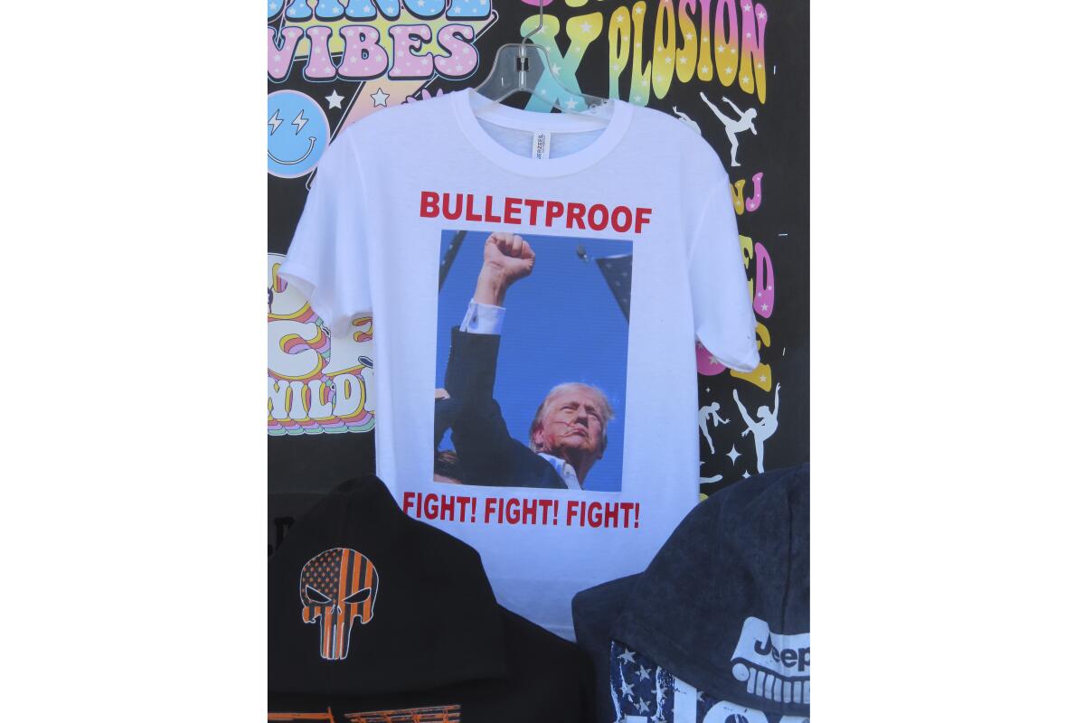 A T-shirt showing Trump fist-pumping reads "Bulletproof" and "Fight! Fight! Fight!"