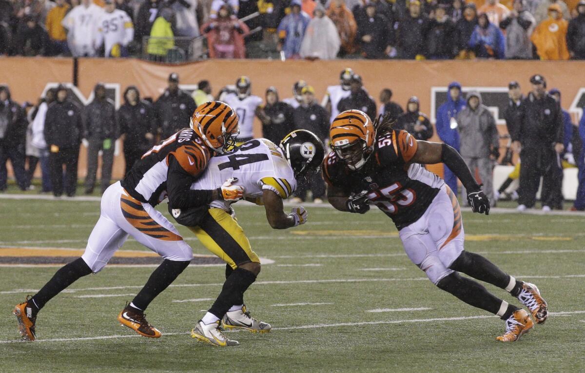Bengals linebacker Vontaze Burfict (55) hits Steelers receiver Antonio Brown (84) on a pass over the middle during the fourth quarter of an NFL playoff game.