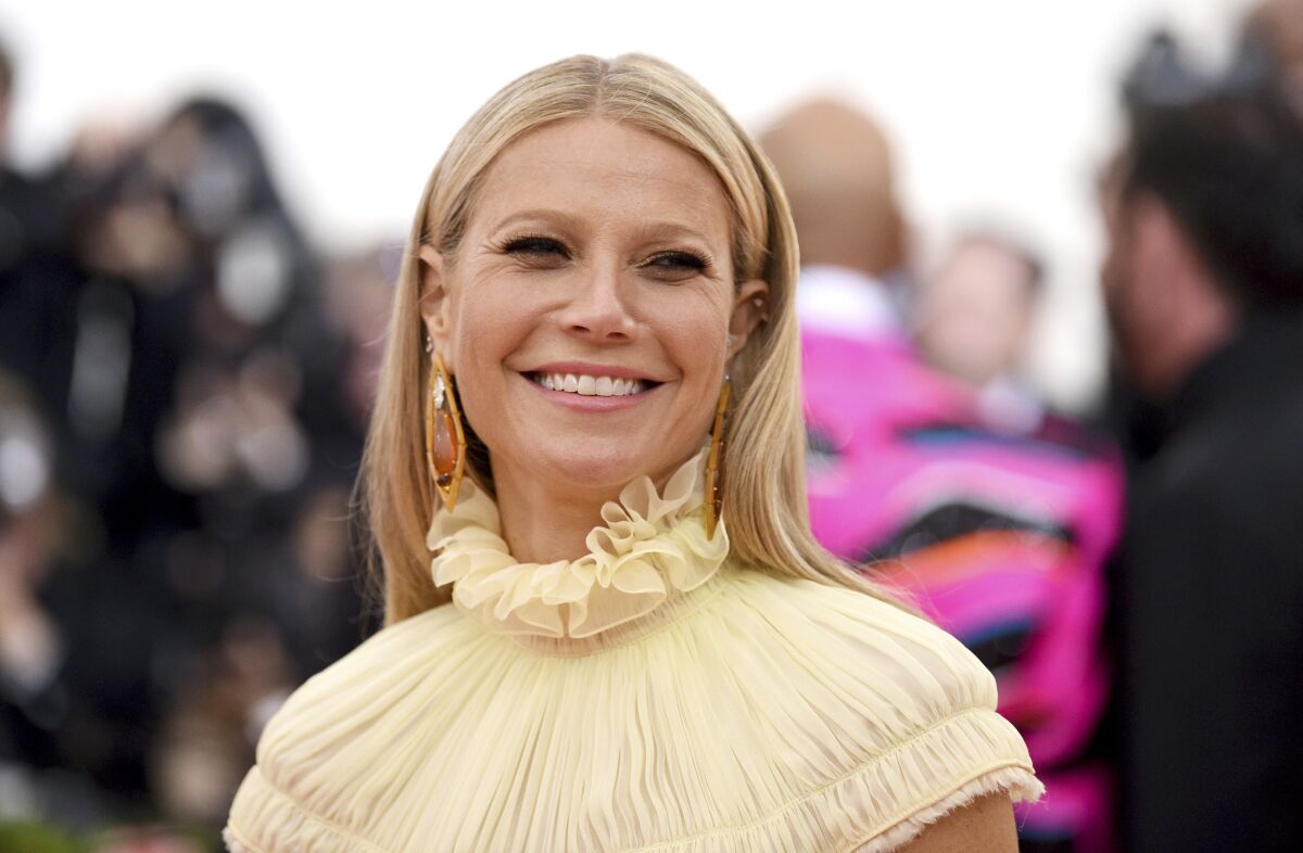 Gwyneth Paltrow smiles at the camera in a tightly framed image that reveals the ruffled neckline on her dress.