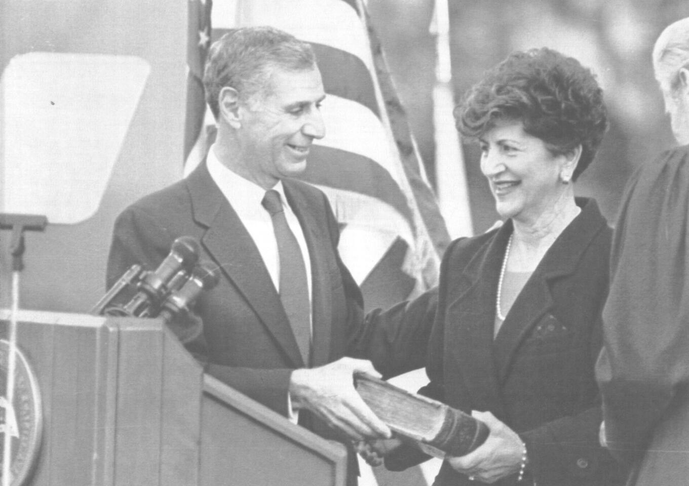 At his inauguration ceremony, Gov. Deukmajian and his wife, Gloria, hold a 486-year-old French Bible on which he took the oath of office.