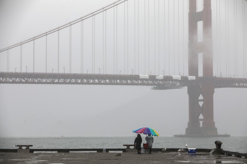 A misty view of the Golden Gate Bridge can be seen from Torpedo Wharf at Fort Point in San Francisco,