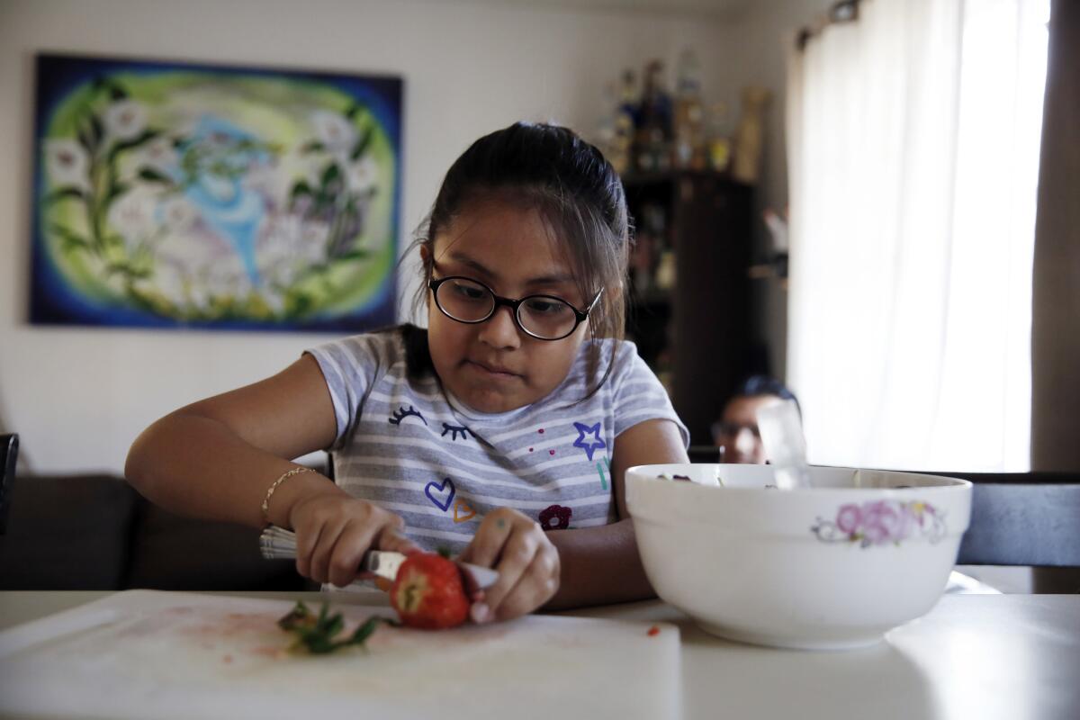 Using a tip she learned in the BodyWorks program the day before, Irie adds strawberries to a salad. (Dania Maxwell / Los Angeles Times)