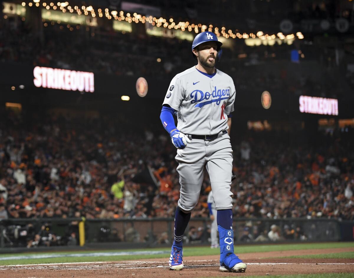 The Dodgers' AJ Pollock walks off the field after striking out during the third inning against the Giants on Oct. 8, 2021.