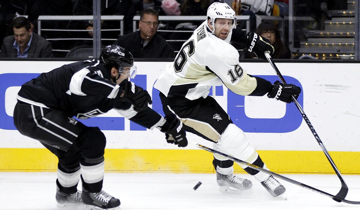 Pittsburgh Penguins right wing Eric Fehr (16) passes the puck against Los Angeles Kings defenseman Jamie McBain (5) during the third period on Saturday.