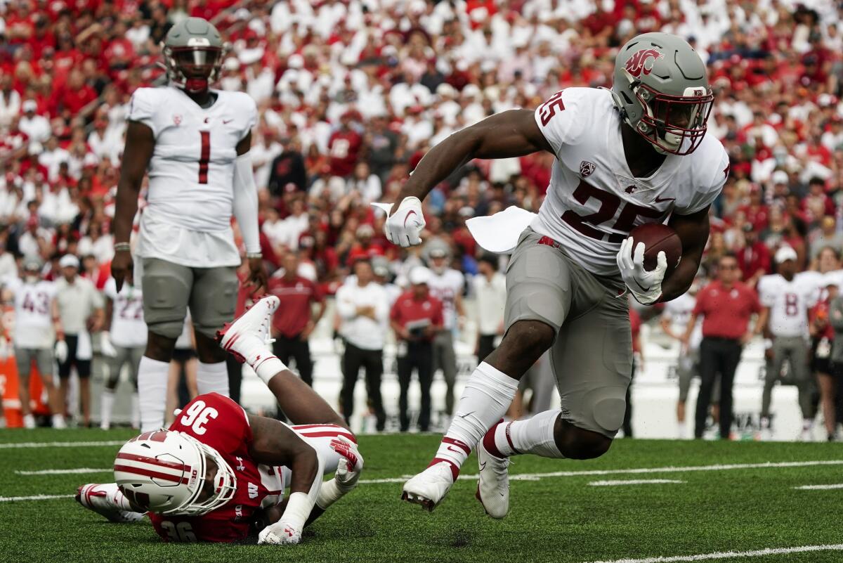 Washington State's Nakia Watson (25) runs past Wisconsin's Jake Chaney (36) during the first half of an NCAA college football game Saturday, Sept. 10, 2022, in Madison, Wis. (AP Photo/Morry Gash)