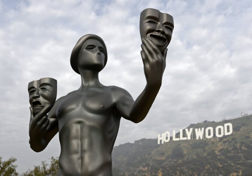 The Hollywood sign looms behind an award statue conferred by the Screen Actors Guild. Employment in film and television is part of what's covered in the recently issued Otis Report on the Creative Economy.