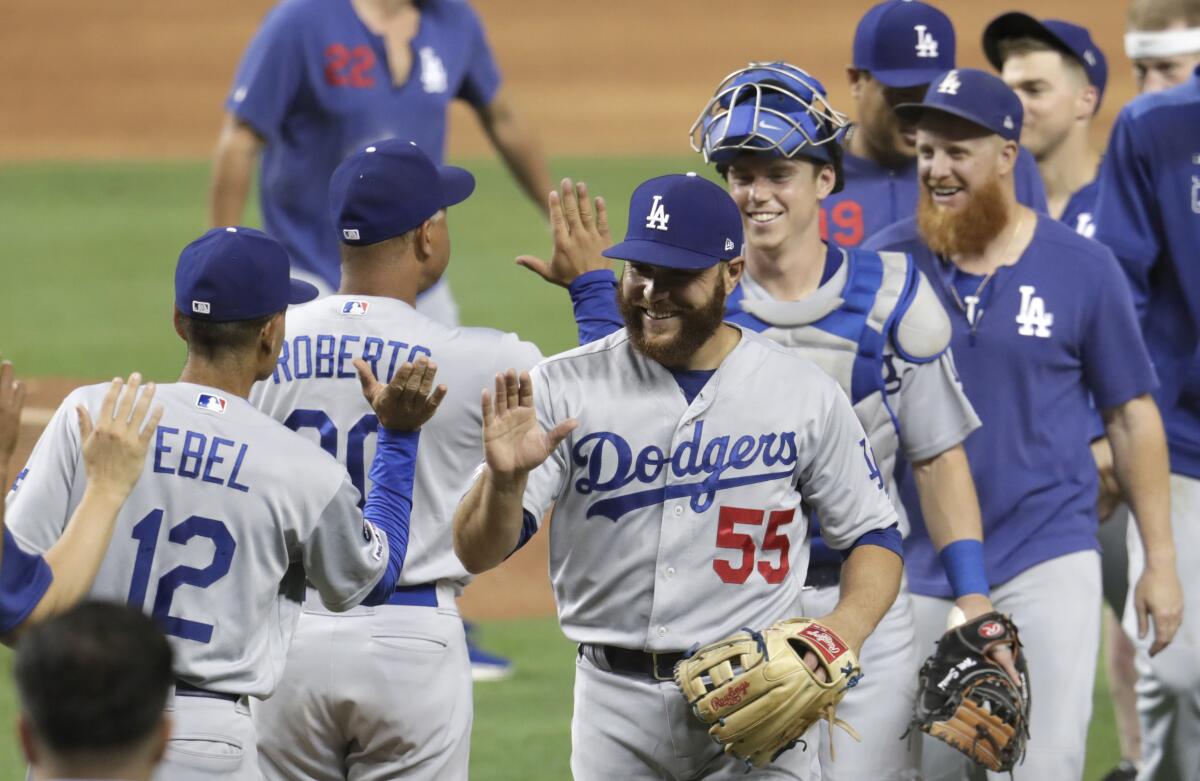 Member of the Dodgers high-five each other after beating the Miami Marlins on Tuesday in Miami. The Dodgers won 15-1.