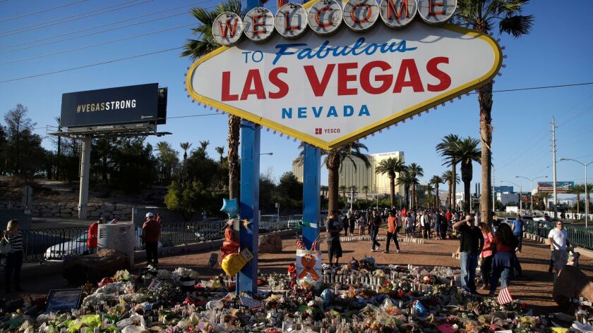 Flowers, candles and other items surround the famous Las Vegas sign at a makeshift memorial for victims of the mass shooting in Las Vegas in October. Visitation numbers and gaming revenue are still down since the Oct. 1 shooting.