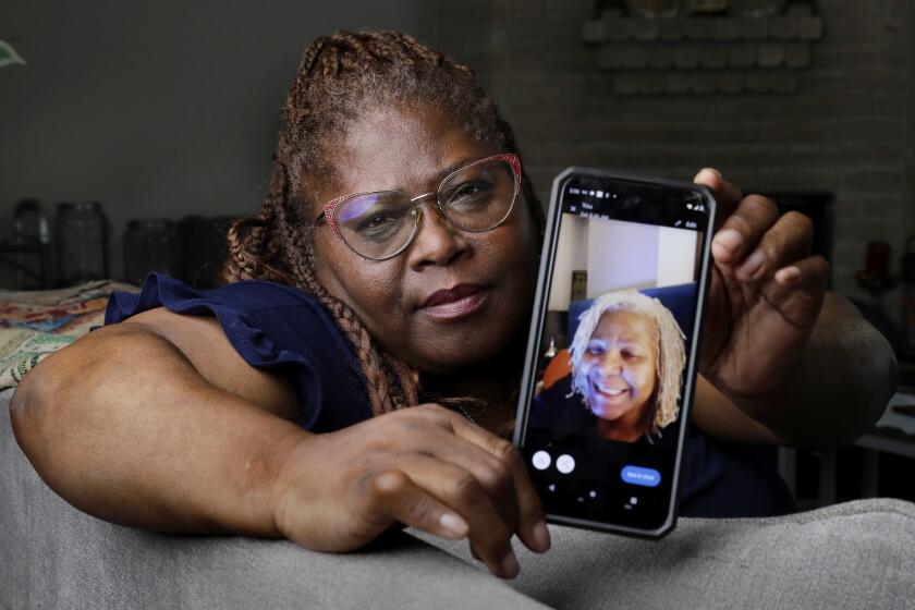 Janet Jarrett shows a photo of her sister, Pamela Jarrett, she keeps on her phone at the home they shared Friday, July 19, 2024, in Spring, Texas. Pamela Jarrett passed away after suffering heat related distress due to the power outage caused by hurricane Beryl. (AP Photo/Michael Wyke)