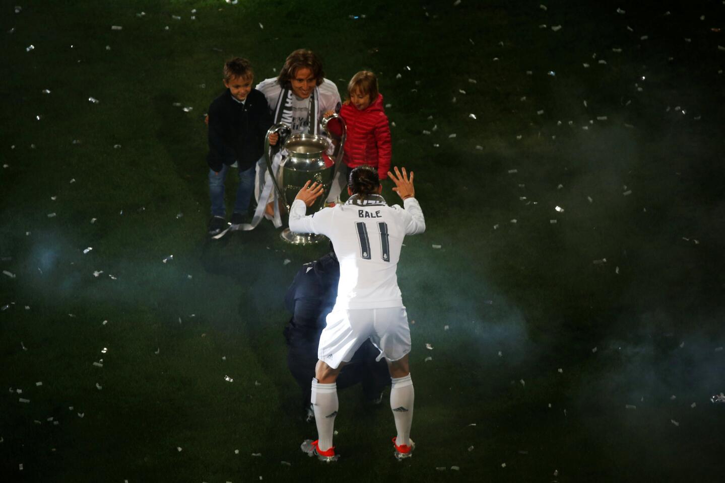 Soccer Football - Atletico Madrid v Real Madrid - UEFA Champions League Final - Santiago Bernabeu Stadium, Madrid, Spain - 29/5/16 Real Madrid's Gareth Bale reacts as teammate Luka Modric poses with his children with the Champions League trophy during a victory ceremony. REUTERS/Susana Vera ** Usable by SD ONLY **
