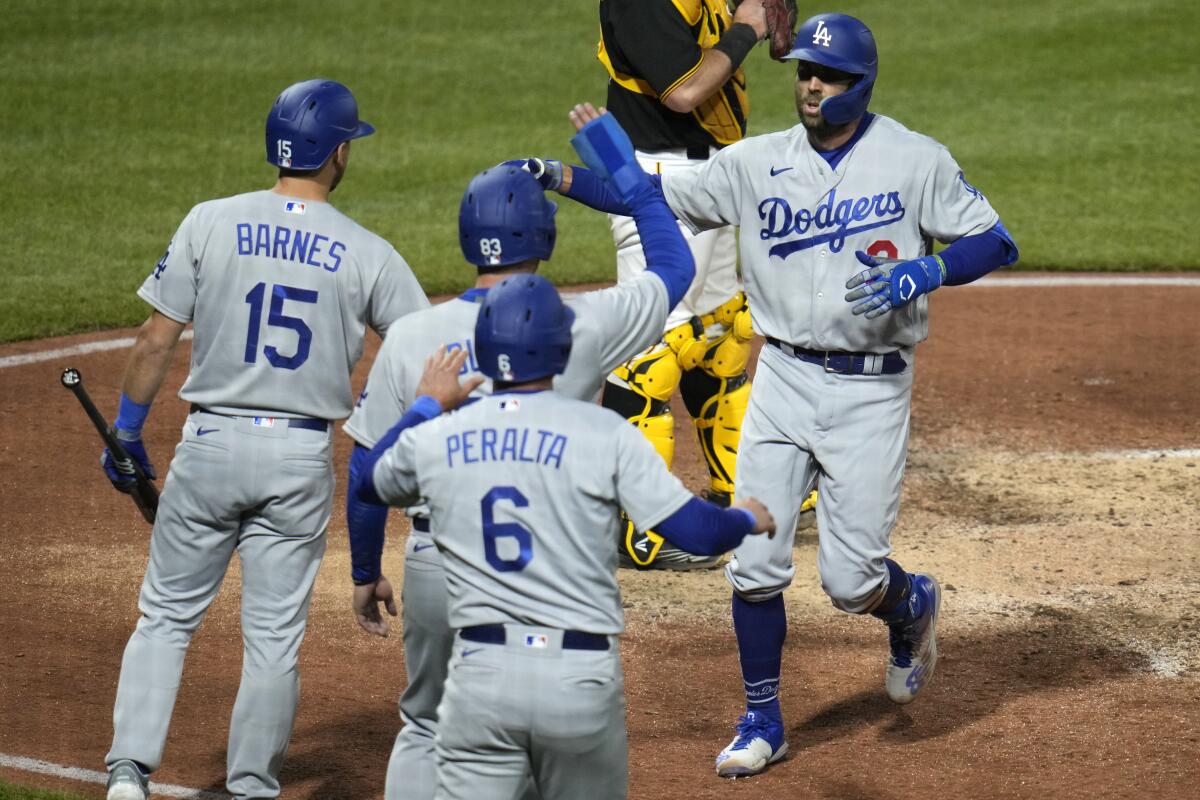 The Dodgers' Chris Taylor is greeted by Austin Barnes, Michael Busch and David Peralta after hitting a three-run home run.