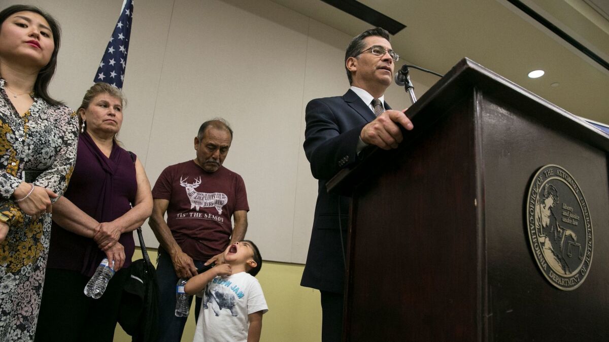 Adam Marquez Lopez, 4, lays out a large yawn in front of his grandfather, Francisco Lopez, as California Attorney General Xavier Becerra conducts a press conference at the John Well Child and Family Center.