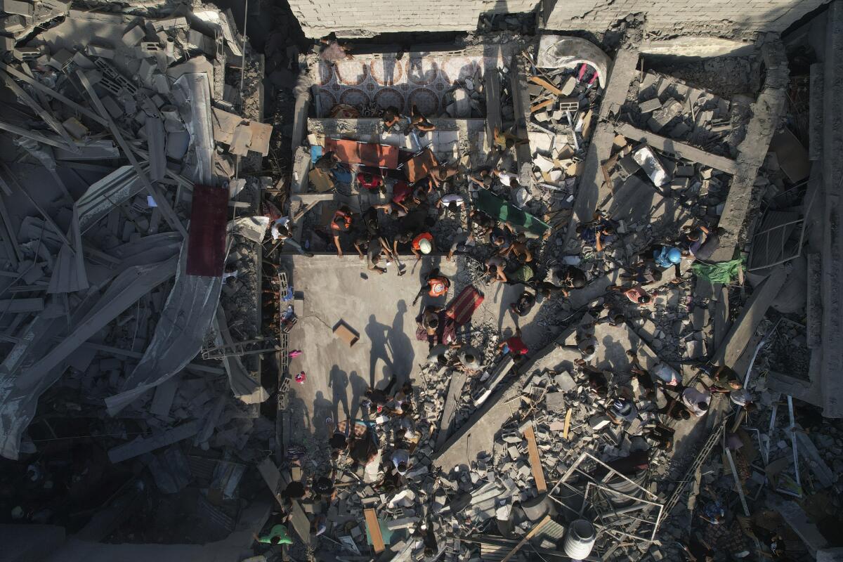 Palestinos inspeccionan los escombros de edificios alcanzados por un ataque aéreo israelí 