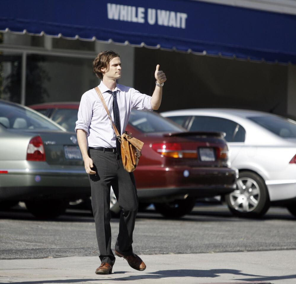 Actor Matthew Gray Grubler, playing Spencer Reid, gives the thumbs up to film crew across the street after filming a scene for the CBS television show Criminal Minds at the corner of Orange and California Aves. in Glendale on Friday, August 10, 2012.