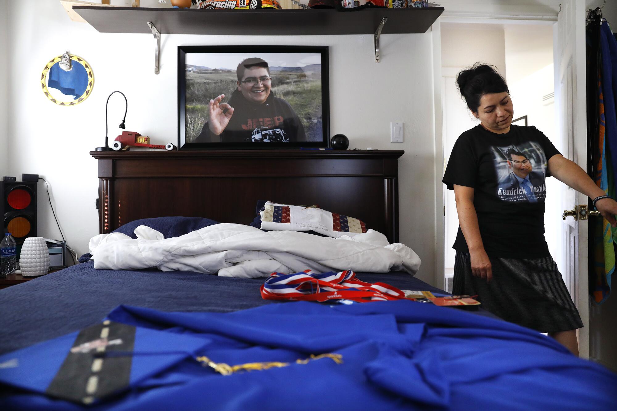 Maria Castillo in her late son's room, where the high school senior's cap and gown still lie on his bed.